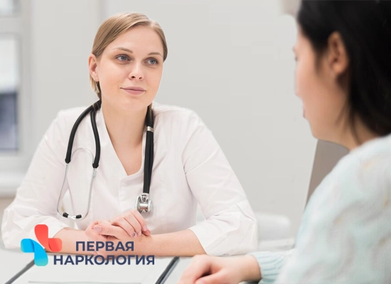Врач сидит за столом с пациентом